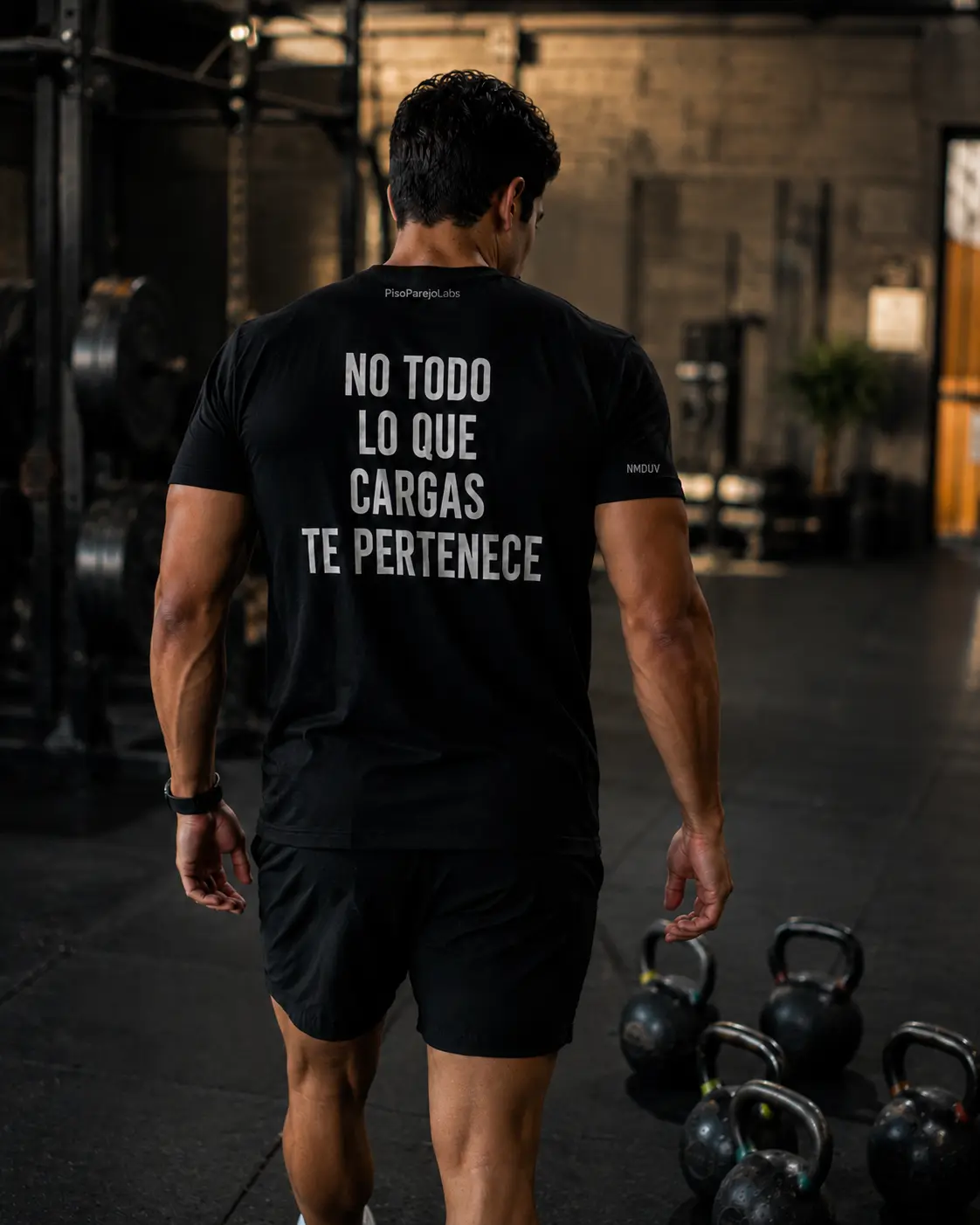 Vista trasera de una camiseta negra con la frase No todo lo que cargas te pertenece.