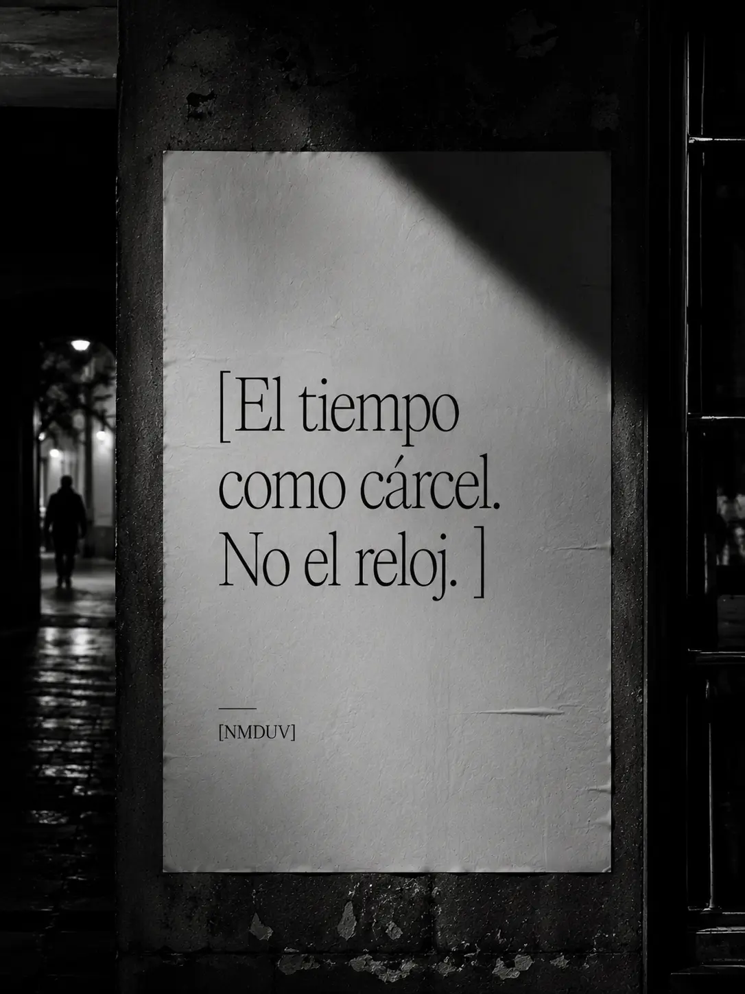 Cartel en una pared nocturna con la frase El tiempo como cárcel. No el reloj.